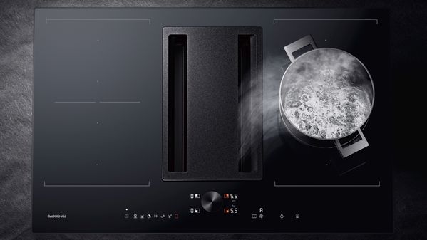 使用中的嘉格纳 200 系列灵活烹饪电磁灶，配备嵌入下吸式吸油烟机